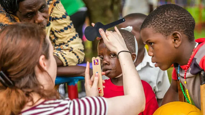 Child undergoing an eye screening outdoors| SpecSMART Eye Clinic Ikoyi