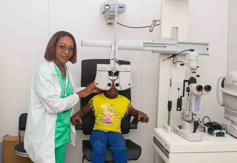 Optometrist conducting a vision test for a young girl using a phoropter at SpecSMART Eye Clinic Ikoyi