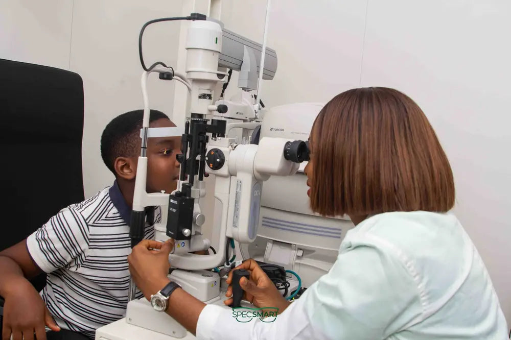 SpecSMART Eye Clinic Ikoyi Optometrist performing an Eye vision test on a boy
