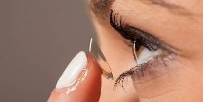 A lady inserting a contact lens| SpecSMART Eye Clinic Ikeja