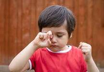Child rubbing eyes, possibly due to irritation or allergy| SpecSMART Eye Clinic Ikoyi