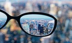 Cityscape blurred except through eyeglass lens, where buildings appear sharp and clear| SpecSMART Eye ClinicIkeja
