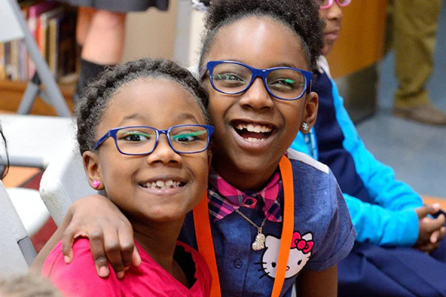 Two smiling girls wearing glasses| SpecSMART Eye Clinic Ikeja